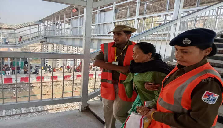 झूसी स्टेशन पर महिला यात्री की मदद करते हुये रेलवे सुरक्षा बल के जवान